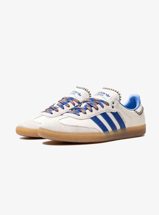 Adidas Samba Wales Bonner Wonder Clay modello IH7756, sneaker in pelle liscia color argilla chiara con dettagli in tessuto crochet sulla linguetta, tre strisce laterali seghettate in pelle scamosciata marrone e finiture in gomma traslucida, design rétro rivisitato in chiave contemporanea. Vista paio laterale